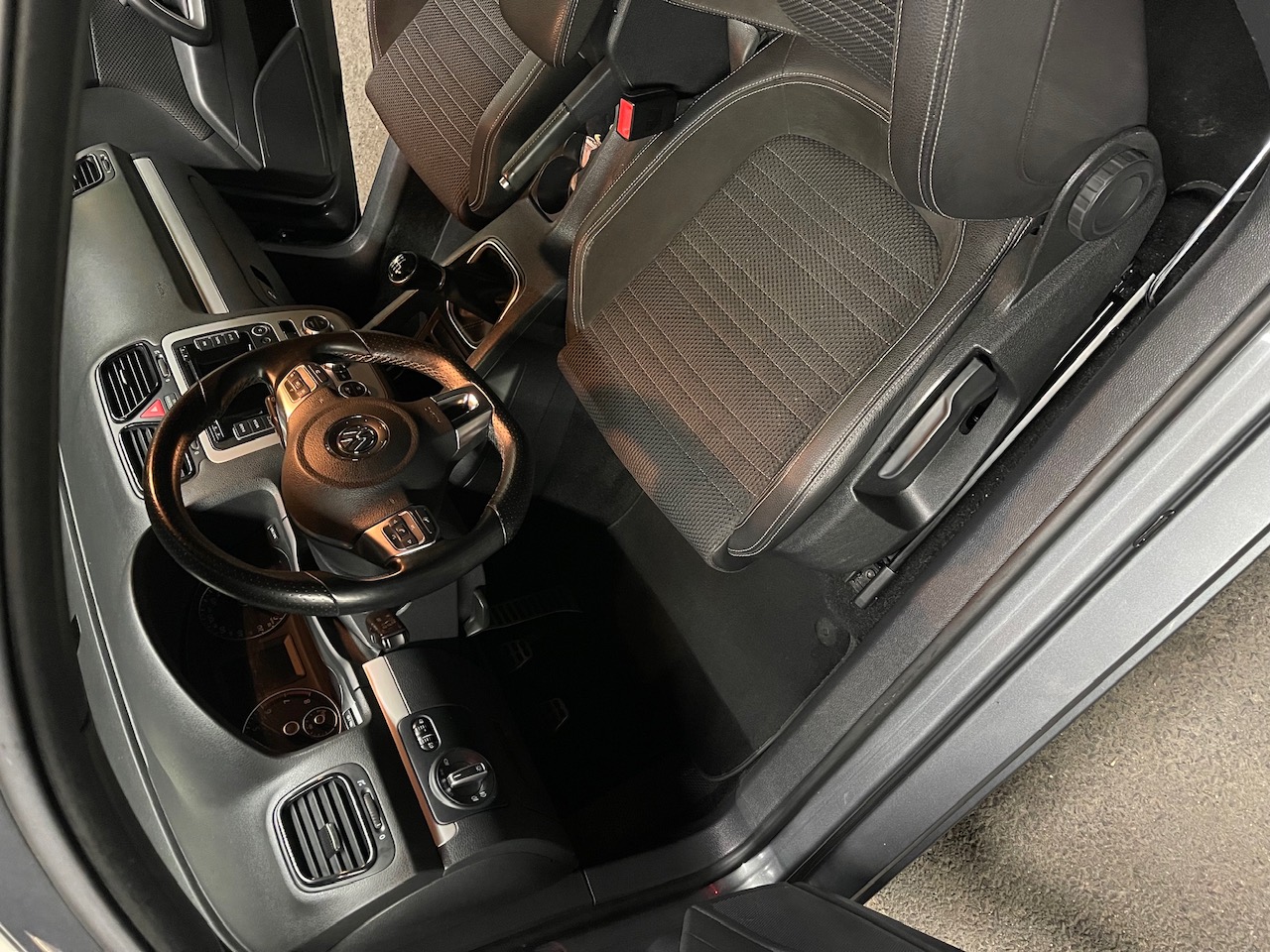 Habitacle d'un coupé Volkswagen nettoyé : sièges, tableau de bord et plastiques traités